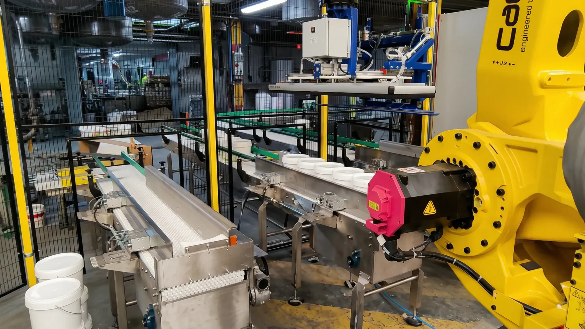 Robot industrial con garra para manipulación de botes de pintura