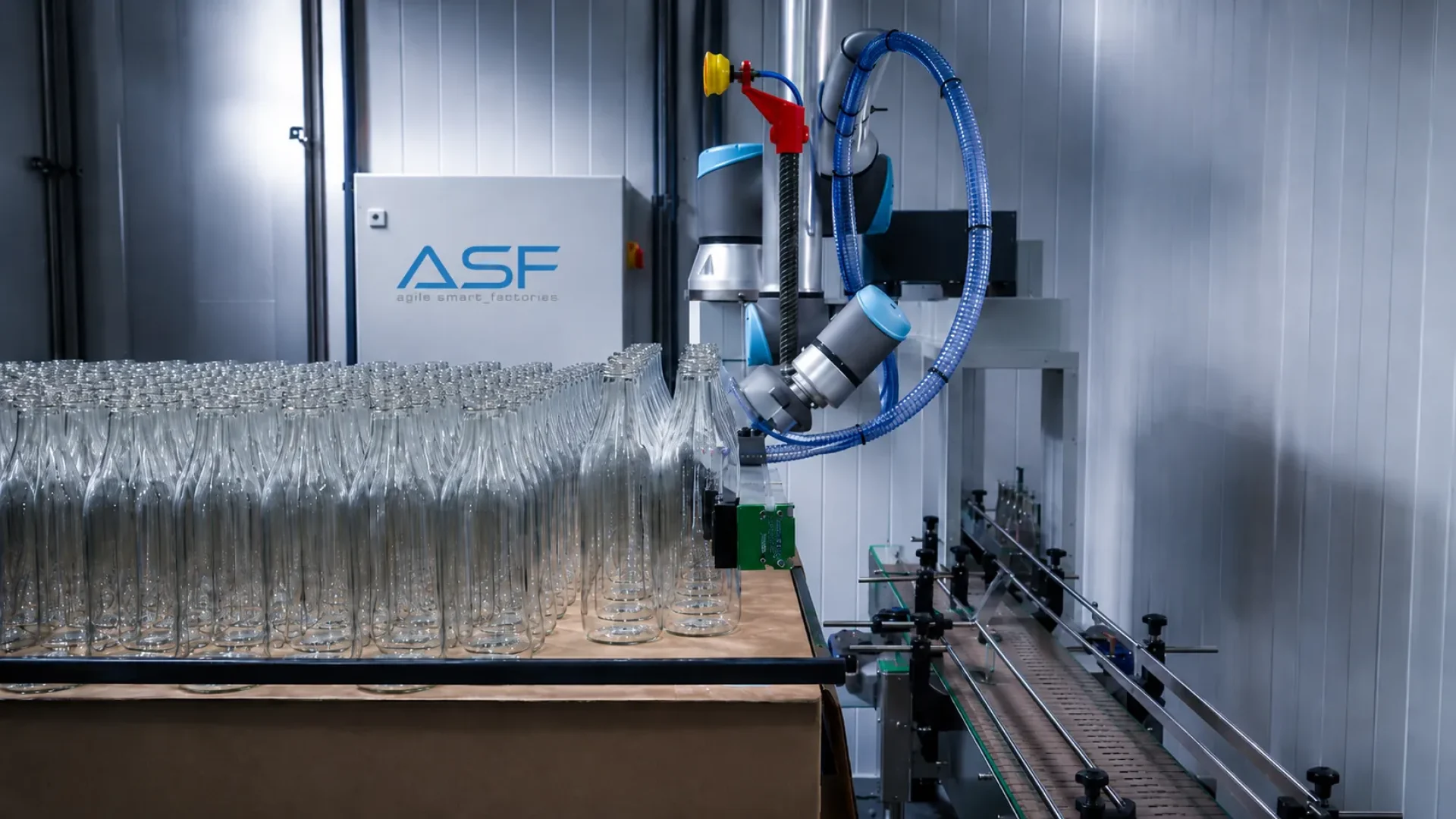Paletizado colaborativo de botellas con robot, garra de ventosas y centrado de palet para formar mosaicos en final de línea.
